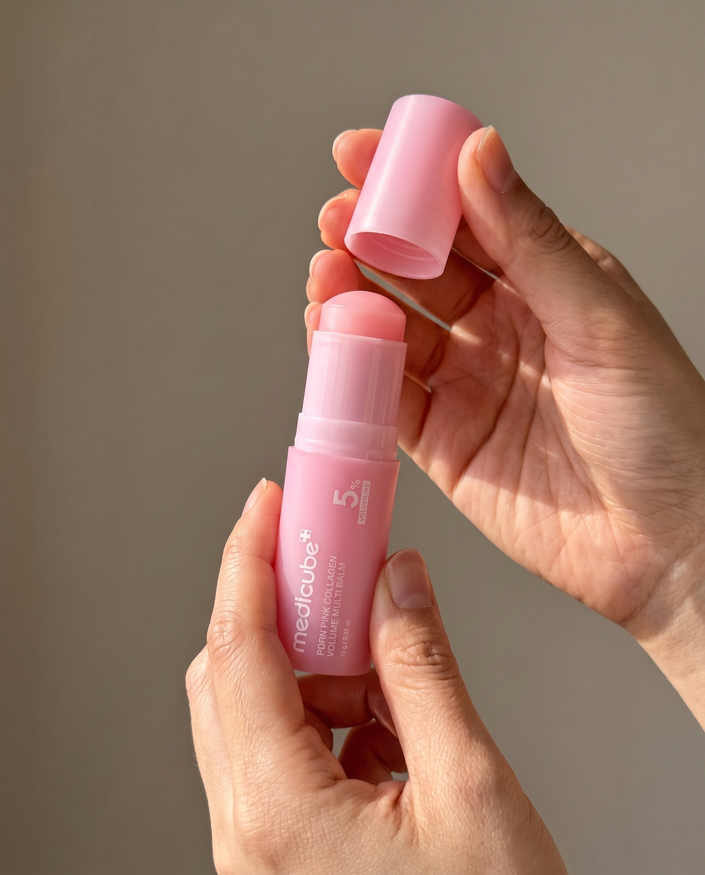 Woman touching up with a balm stick over makeup at her desk